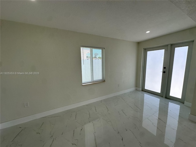 3231 NW 48th Ter, Miami, FL 33142 - spare room featuring a textured ceiling, marble finish floors, french doors, and recessed lighting