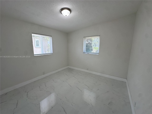 3231 NW 48th Ter, Miami, FL 33142 - spare room with a textured ceiling and marble finish flooring