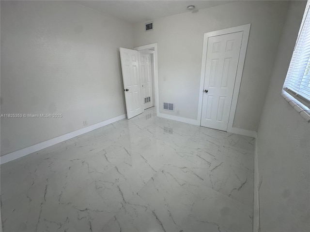 3231 NW 48th Ter, Miami, FL 33142 - unfurnished bedroom with baseboards and light marble finish floors
