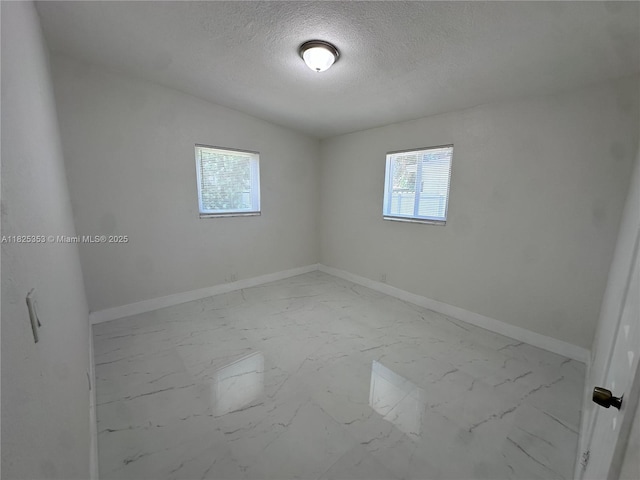 3231 NW 48th Ter, Miami, FL 33142 - spare room featuring marble look tiles and a textured ceiling