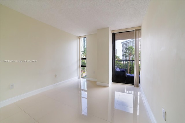 1450 Brickell Bay Dr Unit 311, Miami, FL 33131 - spare room with a textured ceiling, light tile patterned floors, and a wall of windows