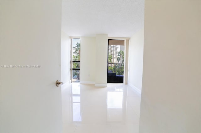 1450 Brickell Bay Dr Unit 311, Miami, FL 33131 - hall featuring tile patterned floors, a textured ceiling, and expansive windows