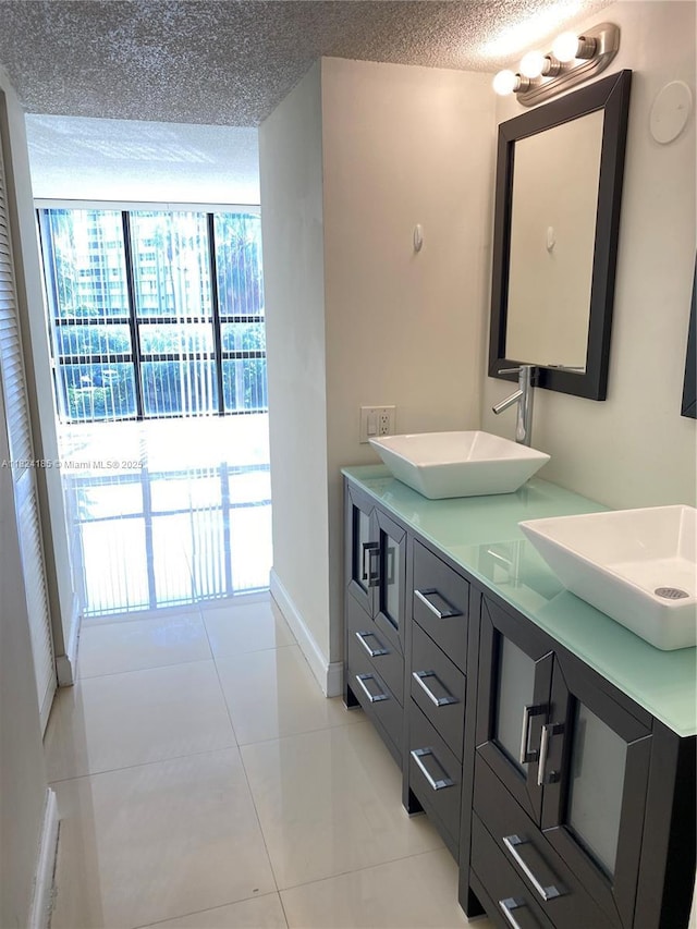 1450 Brickell Bay Dr Unit 311, Miami, FL 33131 - bathroom with double vanity, tile patterned flooring, and a textured ceiling
