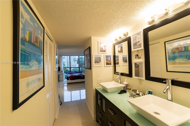 1450 Brickell Bay Dr Unit 311, Miami, FL 33131 - full bathroom with double vanity, tile patterned flooring, and a textured ceiling