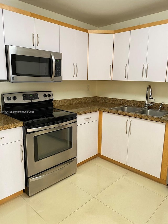 1450 Brickell Bay Dr Unit 311, Miami, FL 33131 - kitchen with stainless steel appliances, white cabinetry, and dark countertops