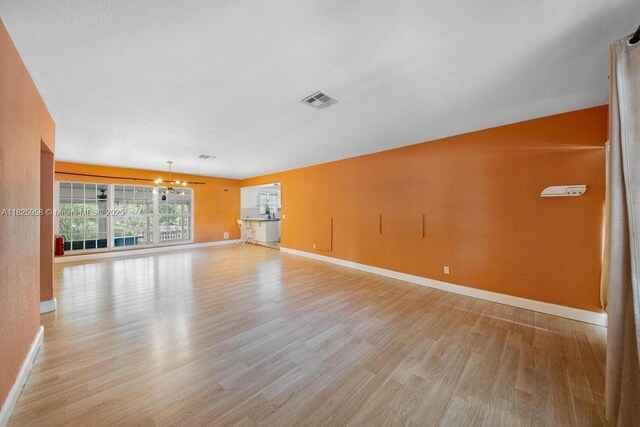 12995 NE 5th Ave, North Miami, FL 33161 - spare room featuring light wood-style floors and a chandelier