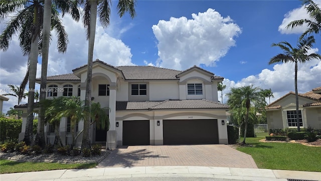 1425 Crossbill Ct, Weston, FL 33327 - mediterranean / spanish home featuring a tile roof, a garage, stucco siding, decorative driveway, and a front lawn