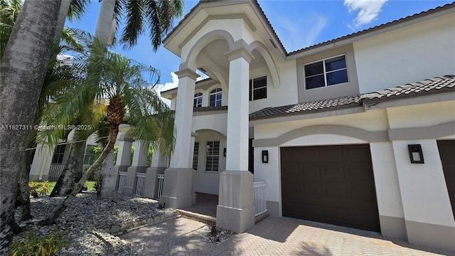 1425 Crossbill Ct, Weston, FL 33327 - mediterranean / spanish home with stucco siding, a garage, a tile roof, and decorative driveway