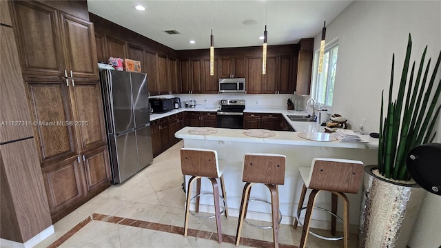 1425 Crossbill Ct, Weston, FL 33327 - kitchen with appliances with stainless steel finishes, a peninsula, light countertops, recessed lighting, and dark brown cabinetry