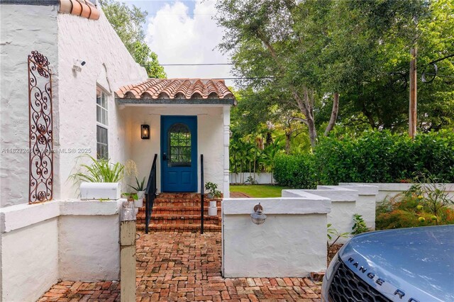 1210 Genoa St, Coral Gables, FL 33134 - view of exterior entry with a tile roof and stucco siding