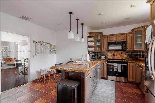 1210 Genoa St, Coral Gables, FL 33134 - kitchen featuring appliances with stainless steel finishes, a peninsula, backsplash, glass insert cabinets, and light stone countertops