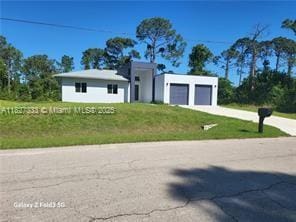 521 S Frank Jewett, Lehigh Acres, FL 33974 - view of front of home featuring a garage, concrete driveway, and a front yard