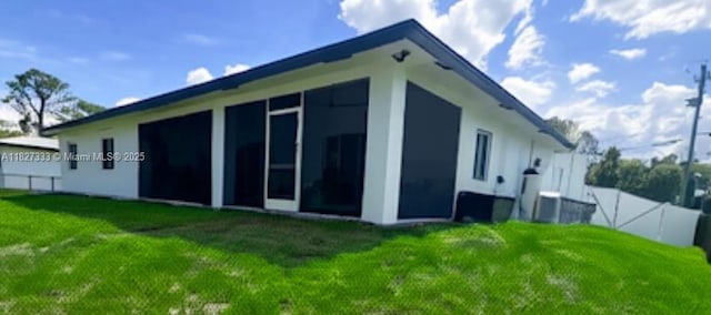 521 S Frank Jewett, Lehigh Acres, FL 33974 - back of property featuring a sunroom and stucco siding