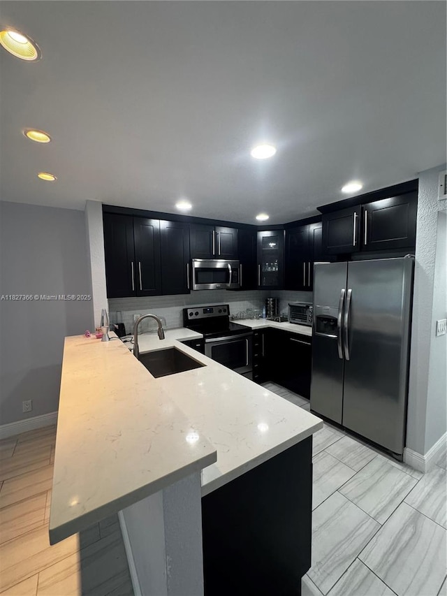 9500 SW 3rd St Unit 239, Boca Raton, FL 33428 - kitchen with stainless steel appliances, dark cabinets, a peninsula, glass insert cabinets, and recessed lighting