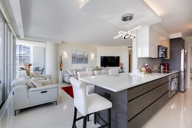 16400 Collins Ave Unit 1845, Sunny Isles Beach, FL 33160 - kitchen with stainless steel appliances, modern cabinets, a kitchen breakfast bar, open floor plan, and hanging light fixtures