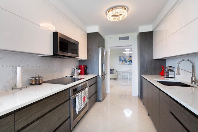 16400 Collins Ave Unit 1845, Sunny Isles Beach, FL 33160 - kitchen with stainless steel appliances, decorative backsplash, modern cabinets, and light stone countertops