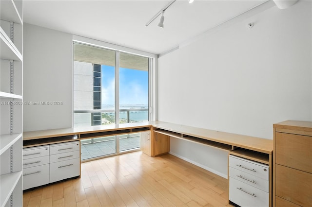 50 Biscayne Blvd Unit 3002, Miami, FL 33132 - unfurnished office featuring built in study area, track lighting, light wood-style flooring, and a wall of windows