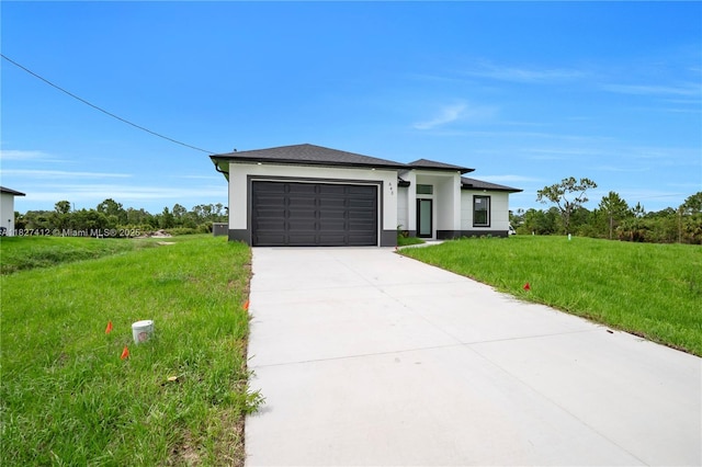 643 Knapp St, Lehigh Acres, FL 33974 - prairie-style home featuring a garage, concrete driveway, a front lawn, and stucco siding