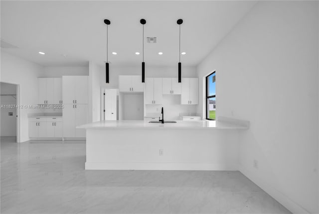 643 Knapp St, Lehigh Acres, FL 33974 - kitchen with white cabinets, recessed lighting, light countertops, light marble finish floors, and decorative light fixtures