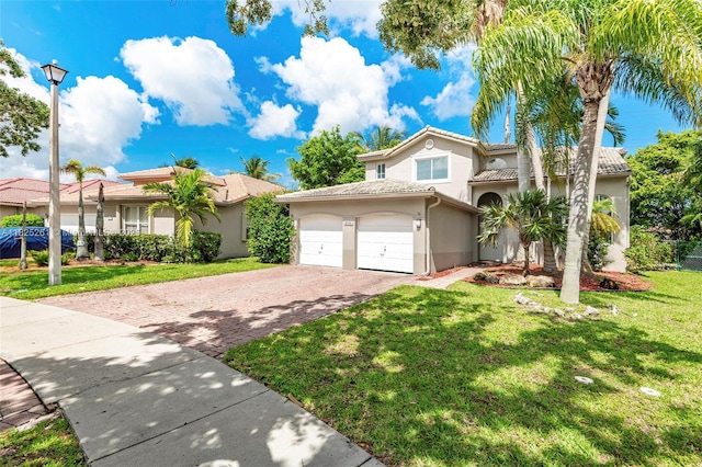 315 W Cypress Cove Cir, Davie, FL 33325 - mediterranean / spanish-style home featuring stucco siding, decorative driveway, a front lawn, a tiled roof, and an attached garage