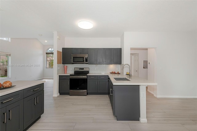 315 W Cypress Cove Cir, Davie, FL 33325 - kitchen featuring appliances with stainless steel finishes, a peninsula, light wood finished floors, decorative backsplash, and light countertops