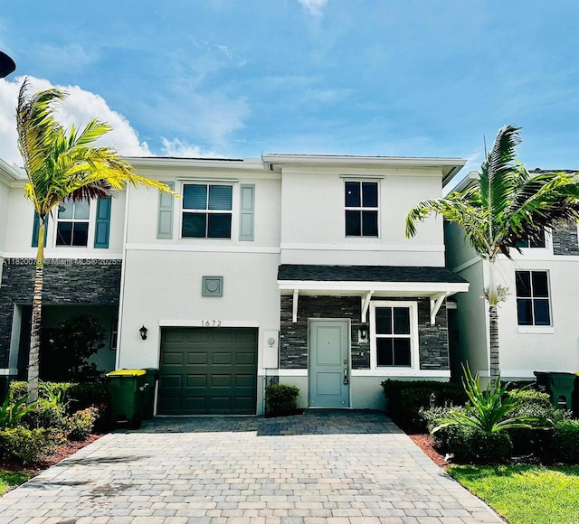 1672 SE 8th Ave, Homestead, FL 33034 - view of front of property featuring stone siding, stucco siding, an attached garage, and decorative driveway