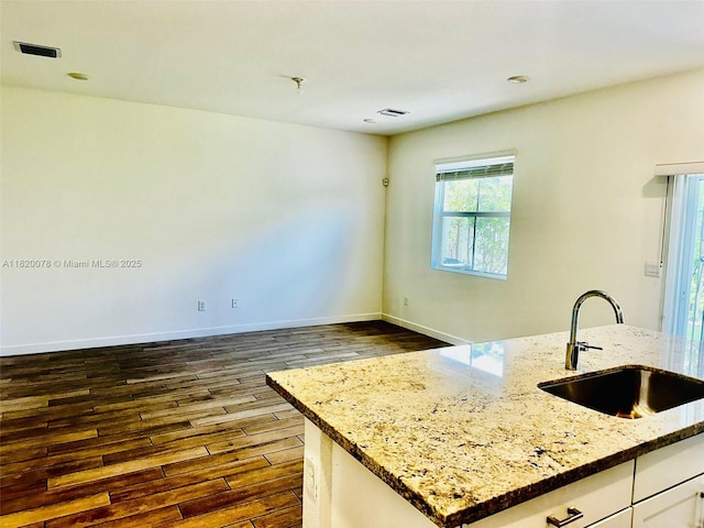 1672 SE 8th Ave, Homestead, FL 33034 - kitchen with dark wood finished floors, white cabinetry, and light stone countertops