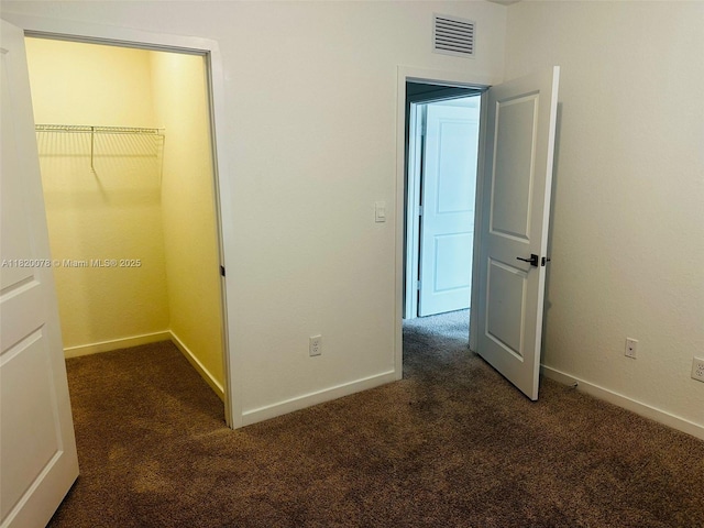 1672 SE 8th Ave, Homestead, FL 33034 - unfurnished bedroom featuring dark colored carpet, a spacious closet, and a closet