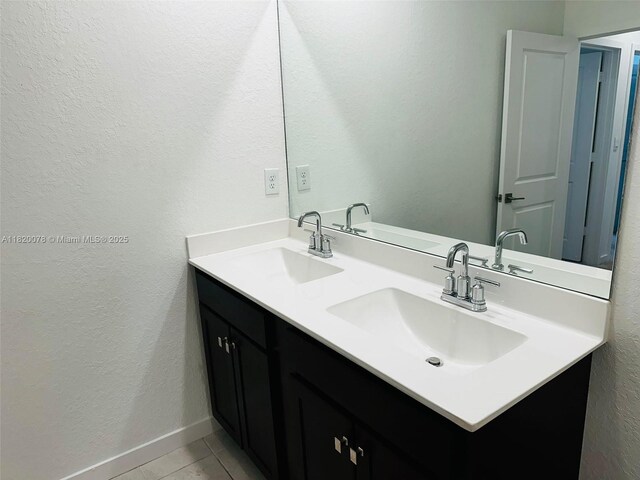 1672 SE 8th Ave, Homestead, FL 33034 - bathroom featuring double vanity, a textured wall, and tile patterned floors