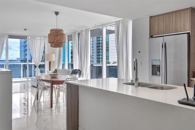 600 NE 27th St Unit 1105, Miami, FL 33137 - kitchen featuring stainless steel refrigerator with ice dispenser, expansive windows, pendant lighting, light tile patterned floors, and light countertops