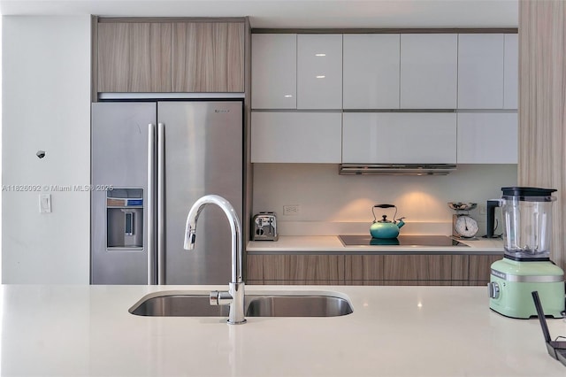 600 NE 27th St Unit 1105, Miami, FL 33137 - kitchen with stainless steel fridge, modern cabinets, light countertops, extractor fan, and black electric stovetop