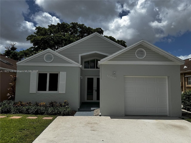 10000 Olive St, Miramar, FL 33025 - ranch-style home featuring stucco siding, french doors, an attached garage, and driveway