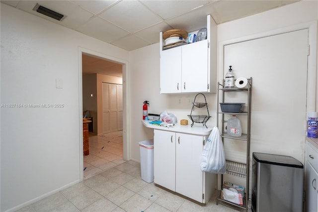 3126 Harbor Blvd Unit 1A, Port Charlotte, FL 33952 - kitchen with light countertops, a drop ceiling, white cabinetry, and light tile patterned flooring