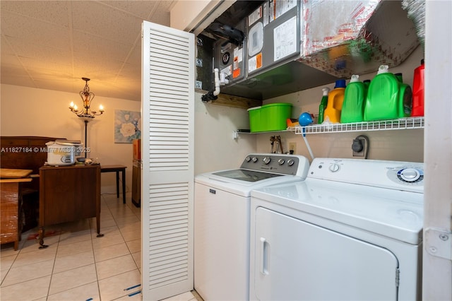 3126 Harbor Blvd Unit 1A, Port Charlotte, FL 33952 - washroom with independent washer and dryer, light tile patterned flooring, and a chandelier