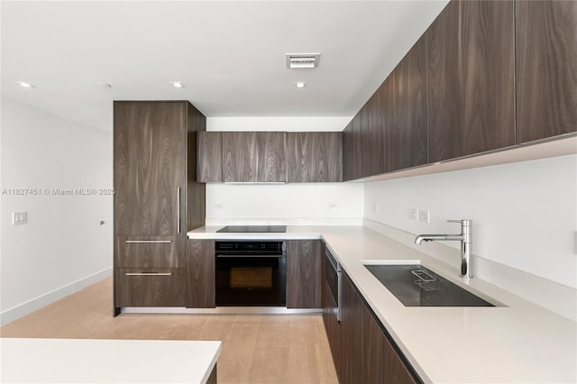 3131 NE 7th Ave Unit 2705, Miami, FL 33137 - kitchen with black appliances, modern cabinets, light countertops, and dark brown cabinetry