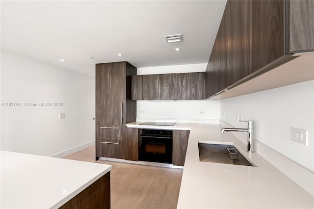 3131 NE 7th Ave Unit 2705, Miami, FL 33137 - kitchen with black appliances, modern cabinets, dark brown cabinetry, and recessed lighting