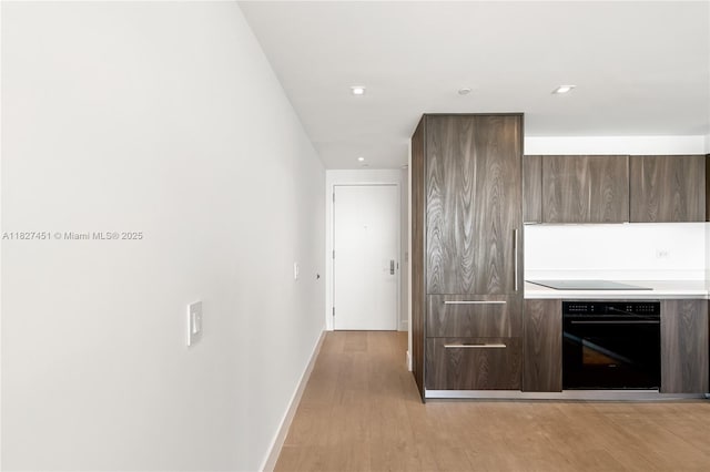 3131 NE 7th Ave Unit 2705, Miami, FL 33137 - kitchen with black appliances, modern cabinets, light countertops, light wood finished floors, and recessed lighting