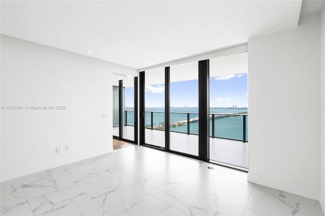 3131 NE 7th Ave Unit 2705, Miami, FL 33137 - empty room featuring floor to ceiling windows, a water view, and light marble finish floors
