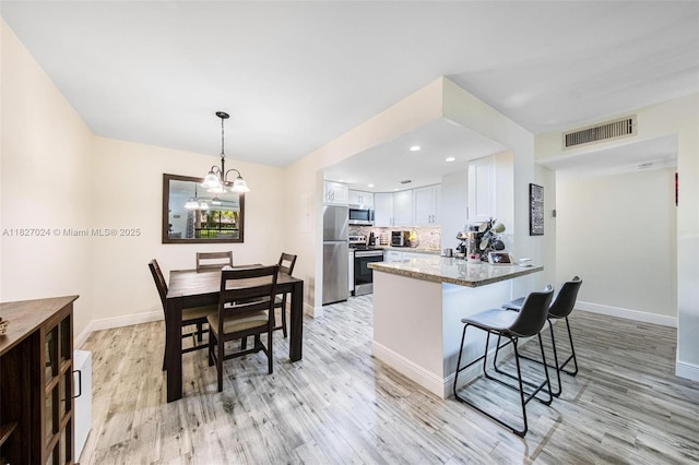 7925 SW 86th St Unit 903, Miami, FL 33143 - kitchen with appliances with stainless steel finishes, light wood finished floors, white cabinetry, a peninsula, and recessed lighting