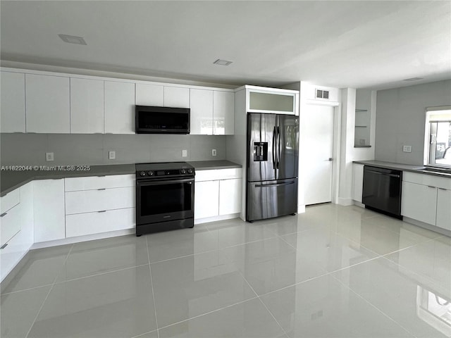 1321 Garfield St, Hollywood, FL 33019 - kitchen featuring stainless steel appliances, modern cabinets, light tile patterned floors, white cabinets, and dark countertops
