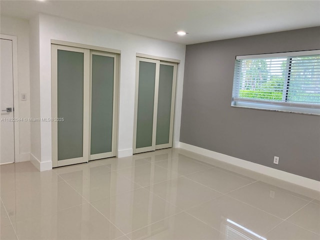 1321 Garfield St, Hollywood, FL 33019 - unfurnished bedroom with tile patterned floors, two closets, and recessed lighting