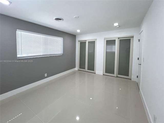 1321 Garfield St, Hollywood, FL 33019 - unfurnished bedroom with multiple closets, tile patterned flooring, and recessed lighting