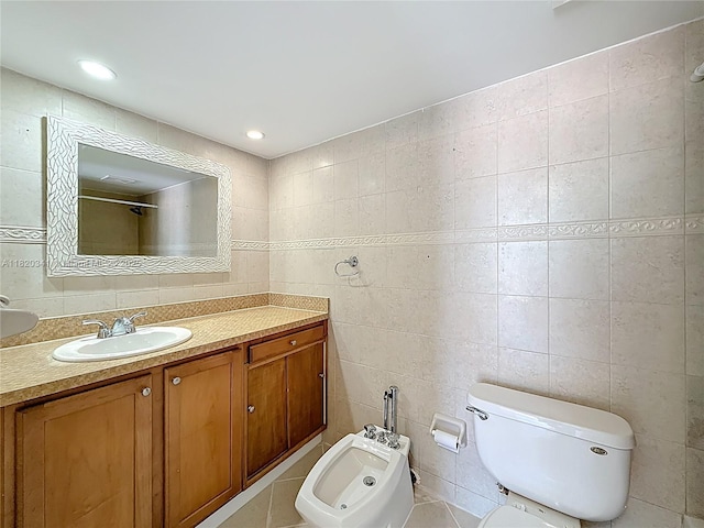 bathroom featuring vanity, a bidet, tile walls, and tile patterned flooring