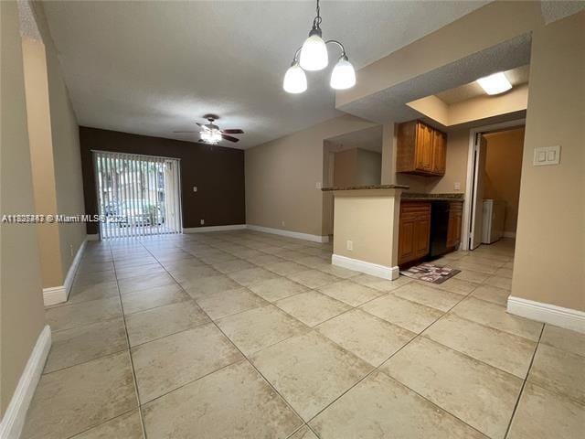 5780 Rock Island Rd Unit 354, Tamarac, FL 33319 - kitchen featuring light tile patterned floors, brown cabinetry, dark countertops, a ceiling fan, and decorative light fixtures