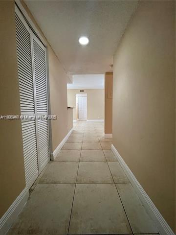 5780 Rock Island Rd Unit 354, Tamarac, FL 33319 - hallway with recessed lighting and light tile patterned floors