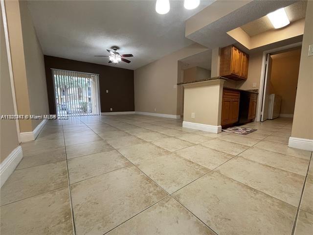 5780 Rock Island Rd Unit 354, Tamarac, FL 33319 - unfurnished living room featuring a ceiling fan and light tile patterned floors