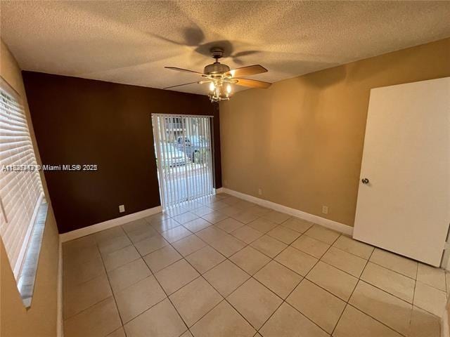 5780 Rock Island Rd Unit 354, Tamarac, FL 33319 - empty room featuring a ceiling fan, plenty of natural light, light tile patterned flooring, and a textured ceiling