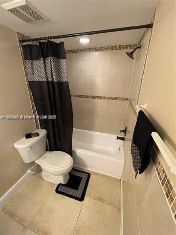 5780 Rock Island Rd Unit 354, Tamarac, FL 33319 - bathroom with shower / tub combo with curtain and tile patterned flooring