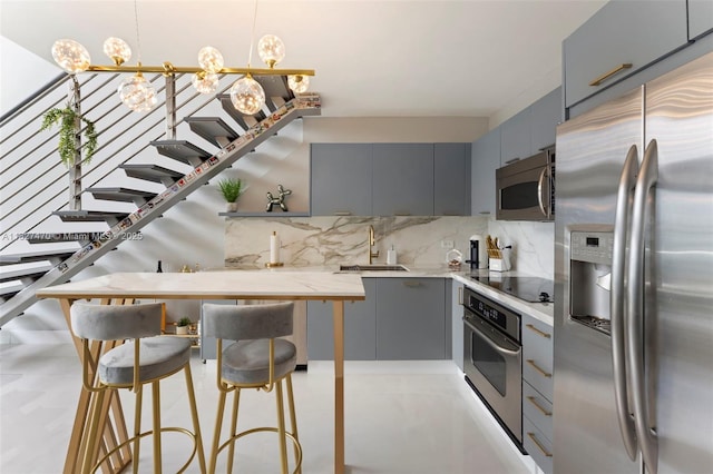 41 SE 5th St Unit 2306, Miami, FL 33131 - kitchen featuring stainless steel appliances, gray cabinetry, decorative backsplash, and modern cabinets