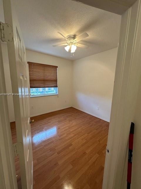 11479 NW 60th Ter Unit 372, Doral, FL 33178 - unfurnished room with a ceiling fan, wood finished floors, and a textured ceiling